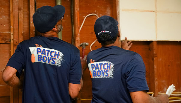 Worker inspection wiring behind drywall