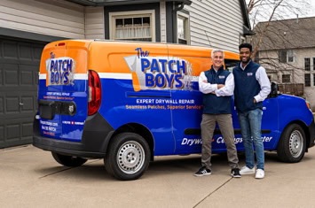 Two employees standing by a work van