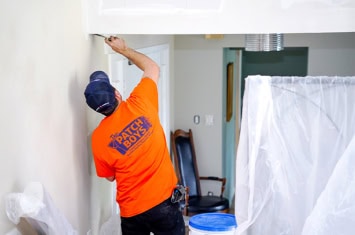 Worker fixing drywall