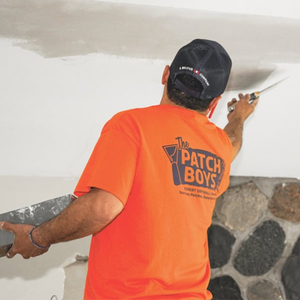 Worker removing popcorn ceiling
