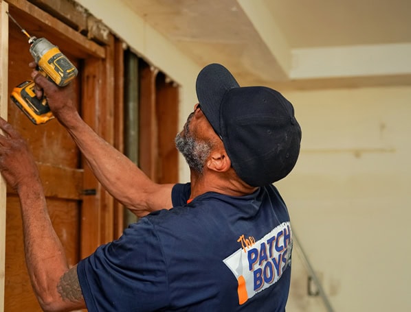 Technician screwing in drywall