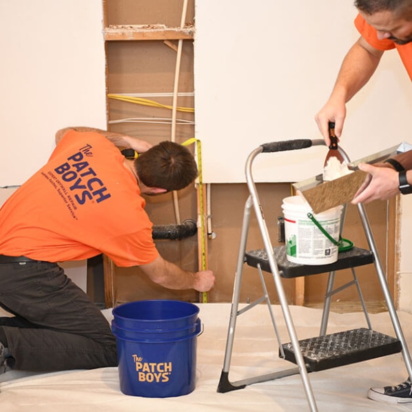 Two men fixing the wall