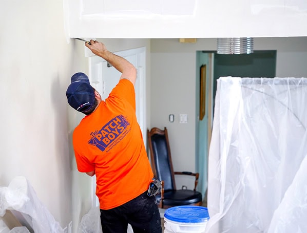Worker fixing drywall