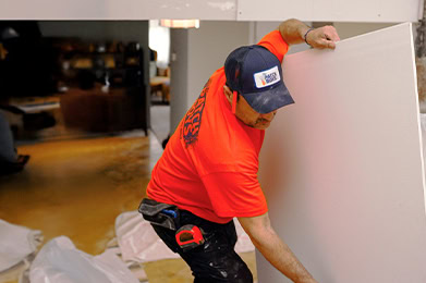 Technician carrying drywall