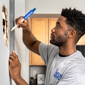 Man repairing drywall inside home