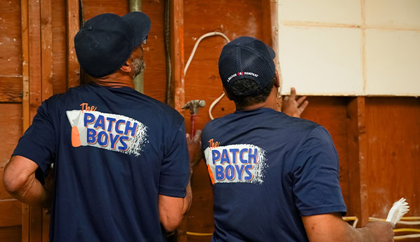 Worker inspection wiring behind drywall