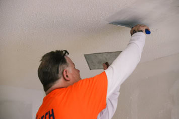 Technician from The Patch Boys repairs a ceiling