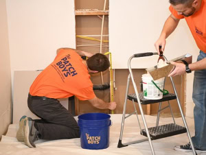Two workers from The Patch Boys doing drywall repair